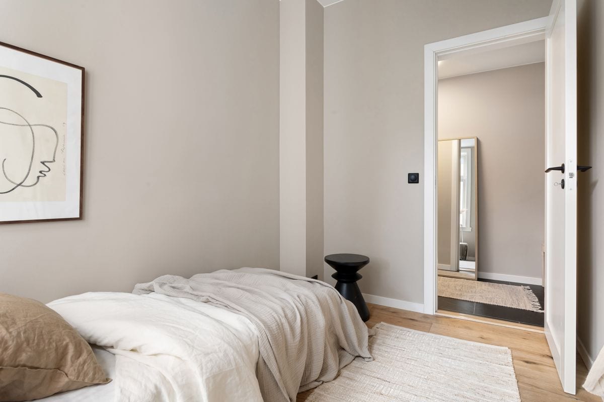 A minimalist studio bedroom with storage bed frame — no floor clutter, maximum calm