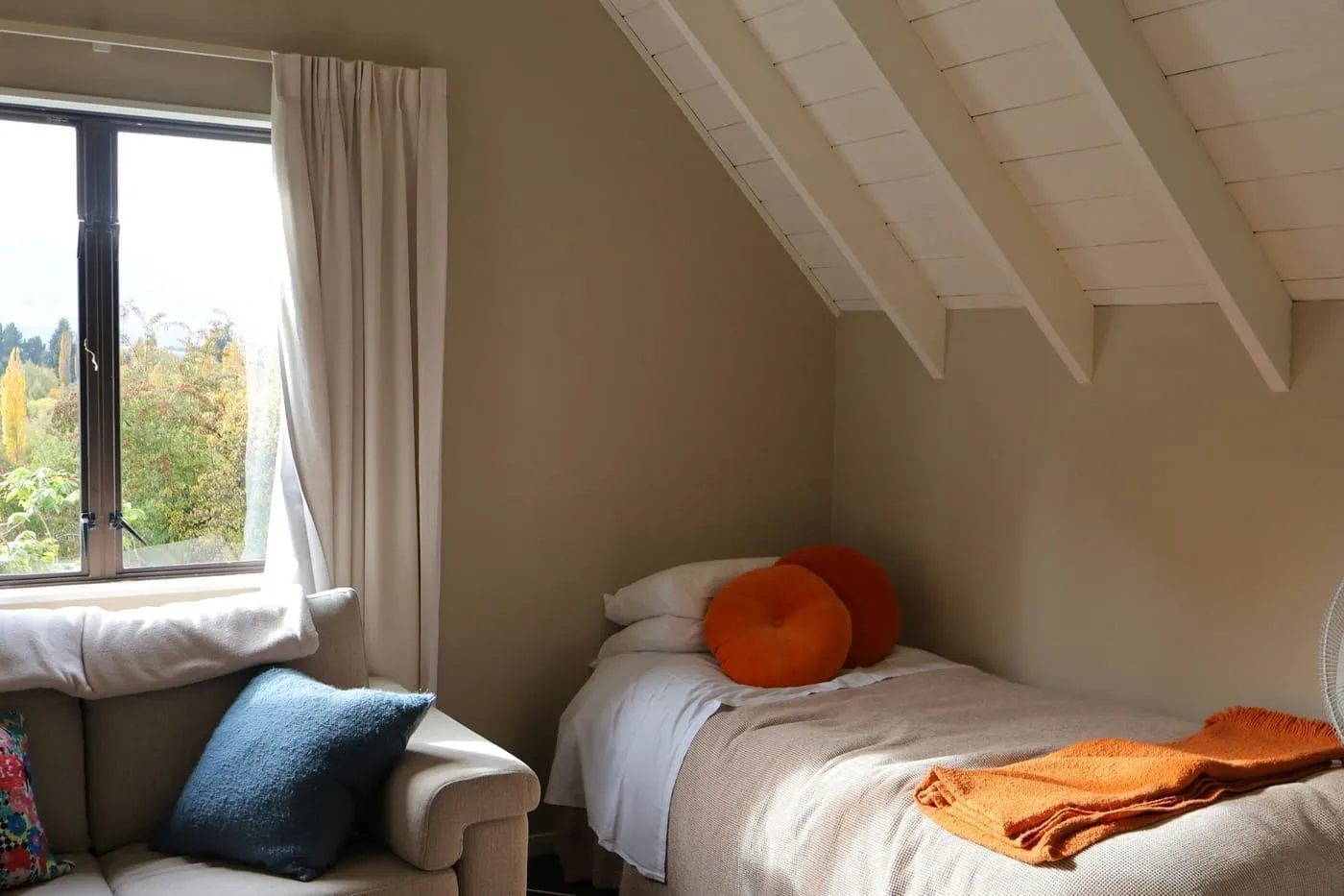 Warm layered bedroom lighting from a bedside lamp creates a calming retreat feel