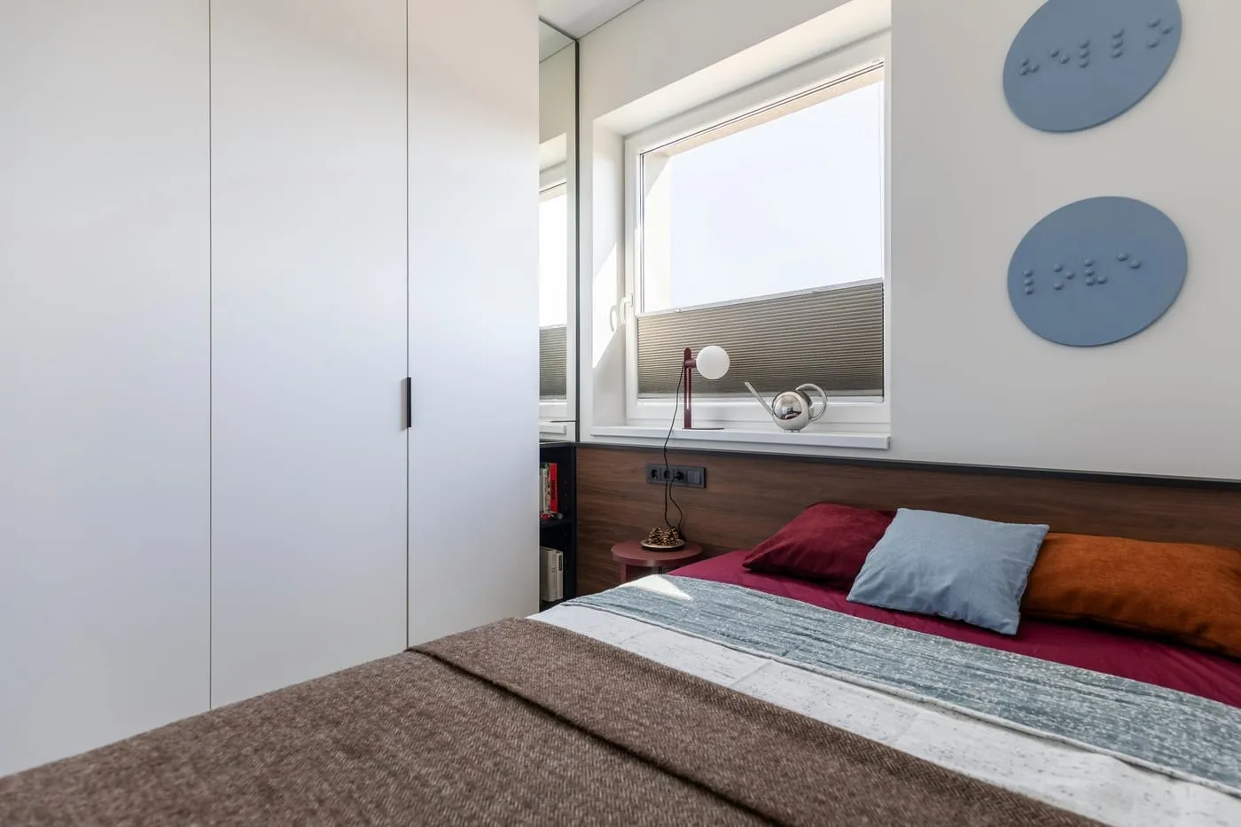 Floating shelves above the bed maximize vertical wall space without taking any floor space