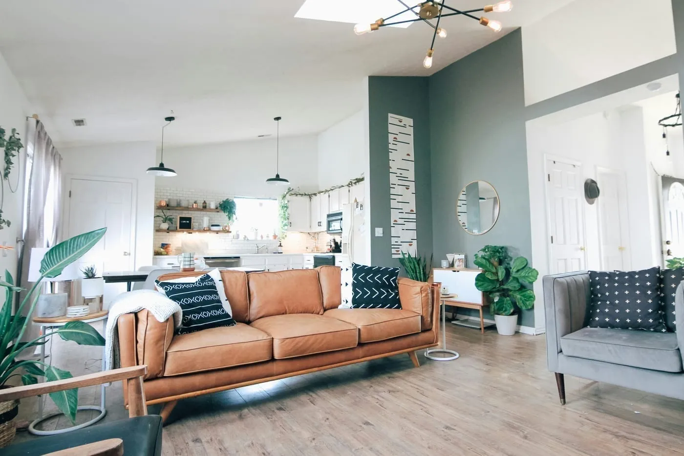 Throw cushions and a blanket layered on a rental apartment sofa — the fastest way to add warmth and colour