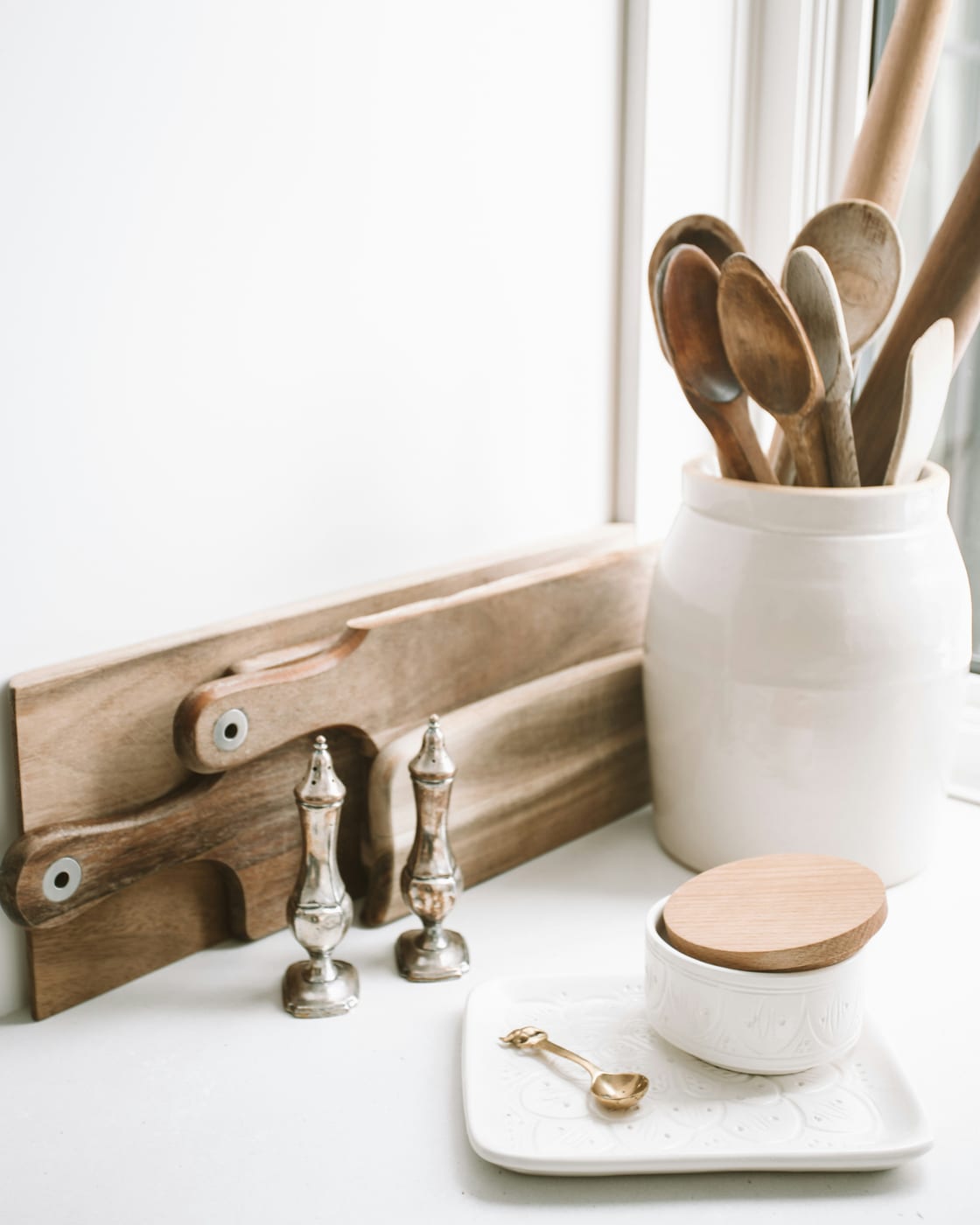 A small apartment kitchen with completely cleared counters — only the coffee maker and one plant remain