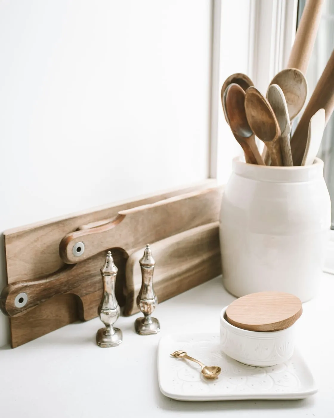 A small apartment kitchen with completely cleared counters — only the coffee maker and one plant remain