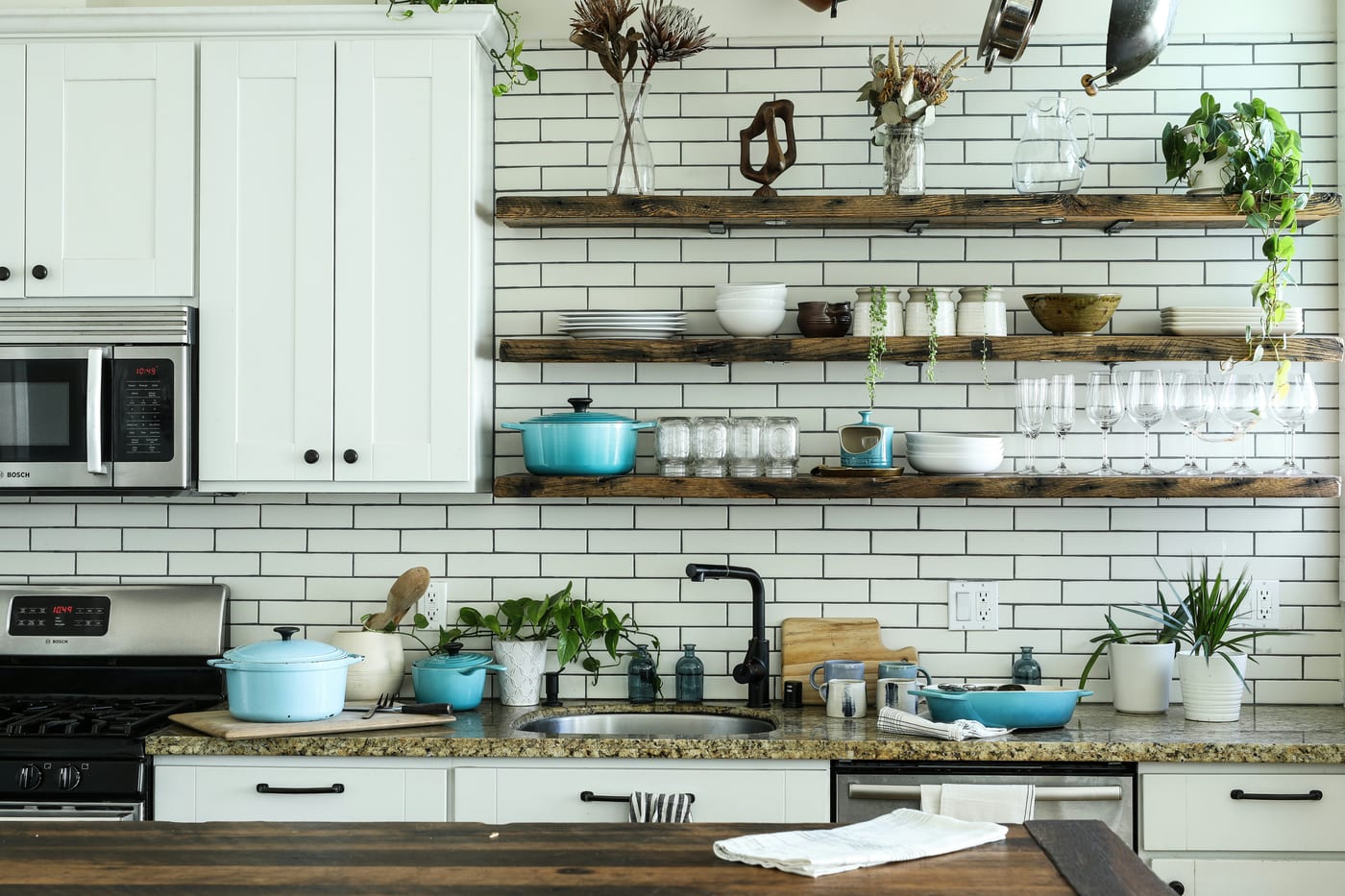 Clear stackable pantry bins labeled by category — everything visible at a glance in a small apartment kitchen