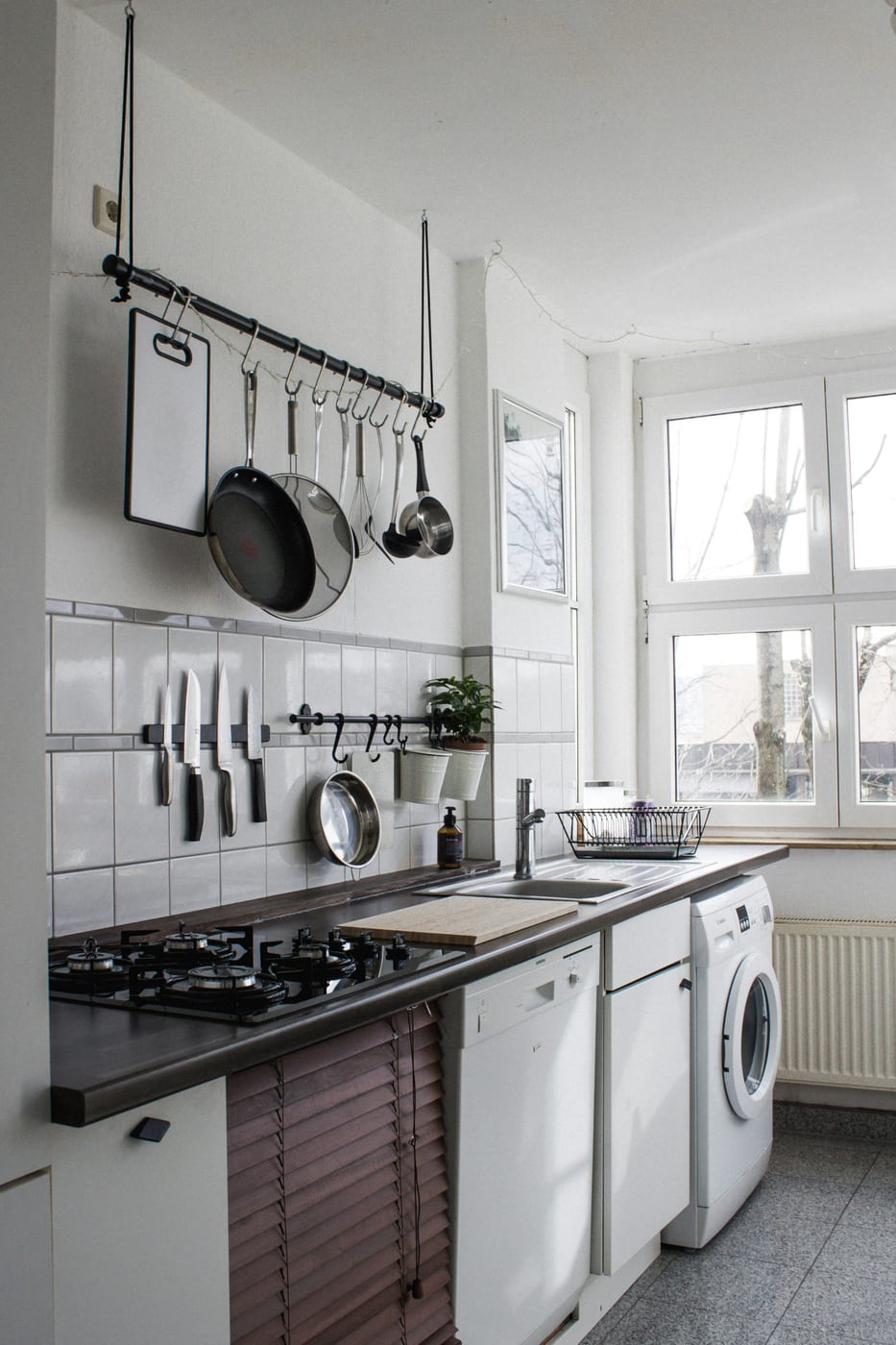 A reset apartment entryway after January — coat hooks, boot tray, and a clear surface for daily essentials