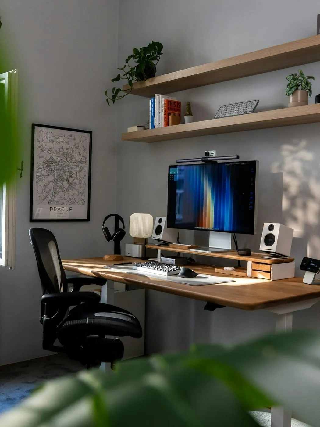 A corner desk with floating shelves above it in a small apartment home office