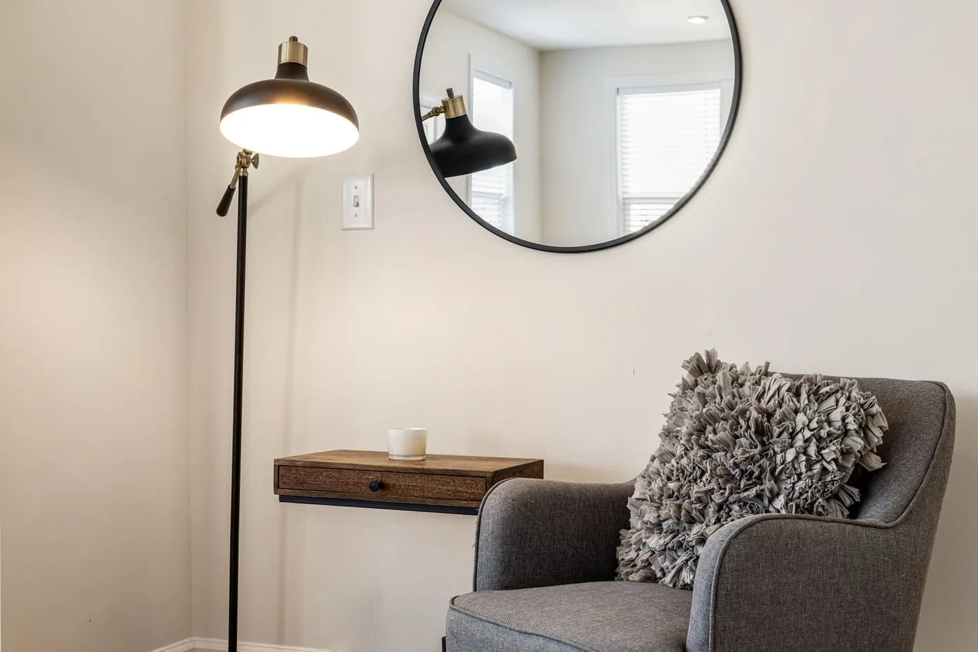Cozy corner styled with a lamp, mirror, and layered Dollarama decor pieces for an expensive-looking small apartment