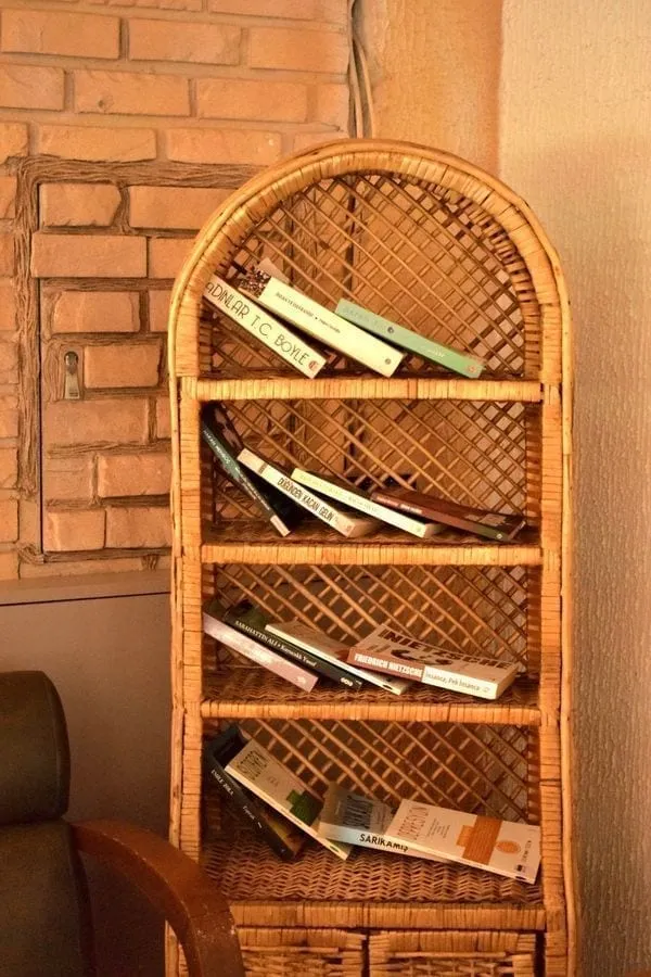 A narrow LACK shelf mounted with Command strips holding folded kitchen towels and a plant